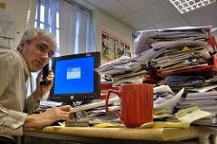 Image of man overwhelmed by paperwork illustrating article on RAFT technique to deal with overload